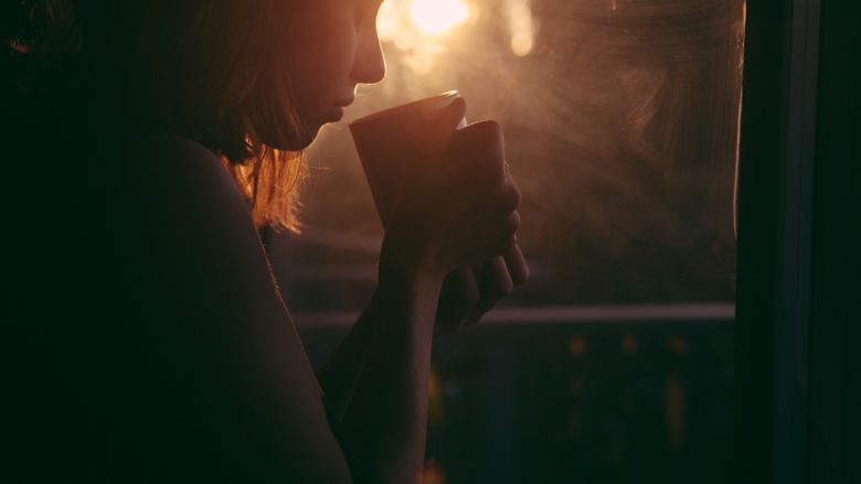 silhouette of person holding cup